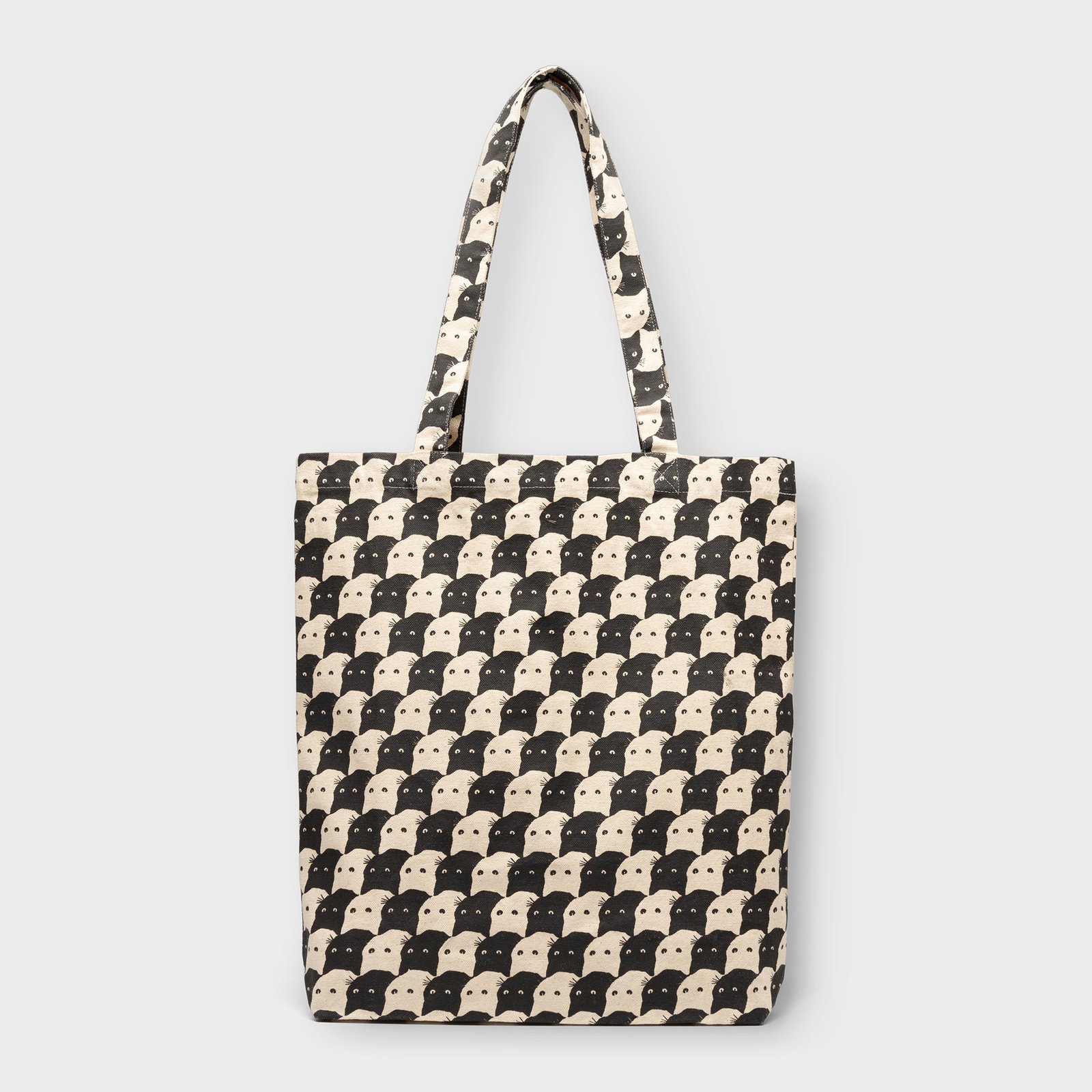 Studio shot of the Tote Bag Torekov in off-white, featuring a graphic all-over print of black and white cat faces.