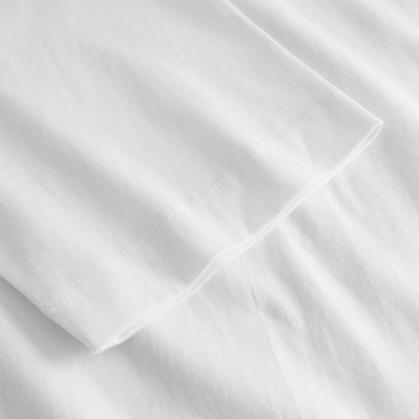 A detailed close-up of the soft, organic cotton fabric and neat double stitching on the sleeve of the T-shirt Vadstena.