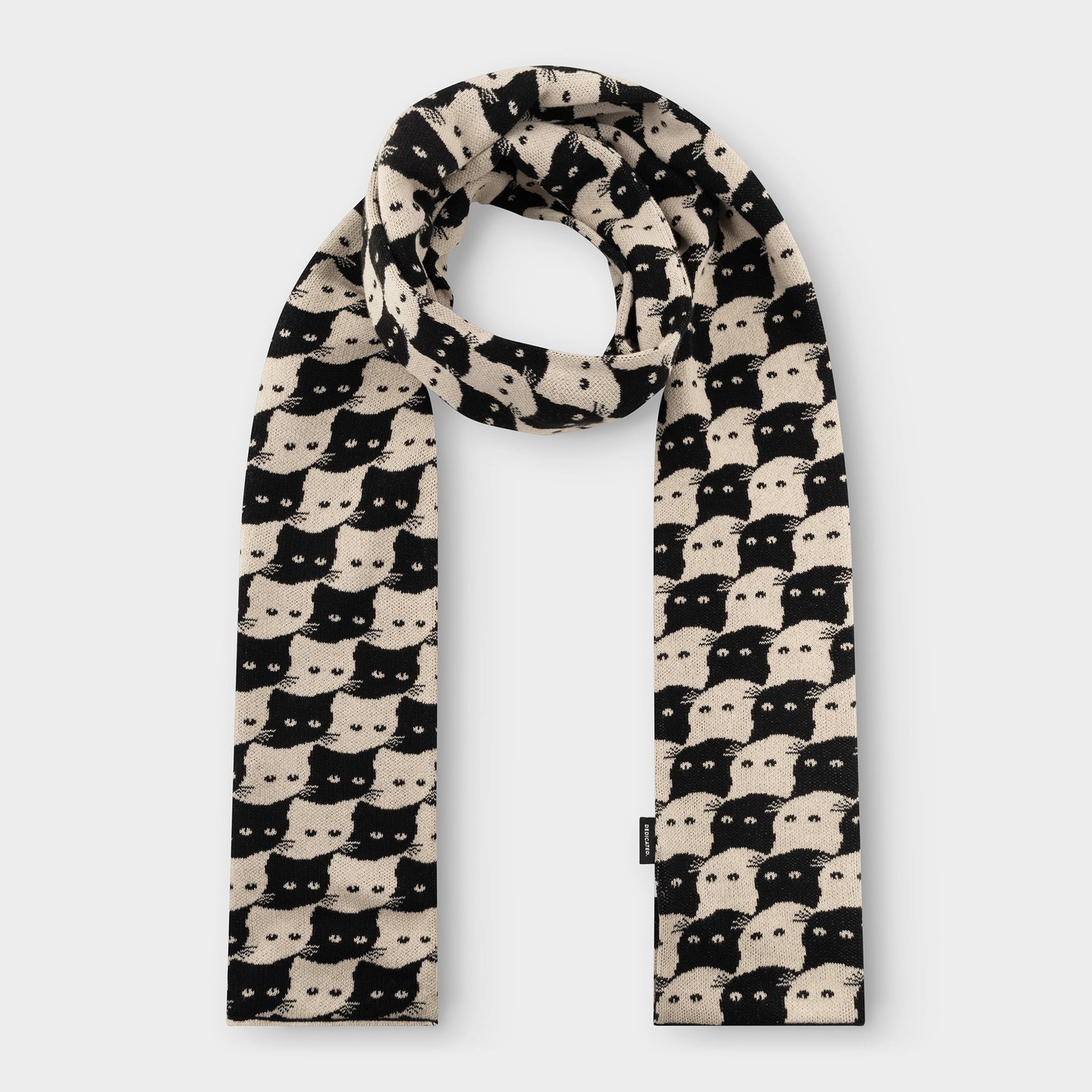 Studio shot of the Rossberga scarf in Oat White, looped to show off its fun, interlocking black and white cat pattern.