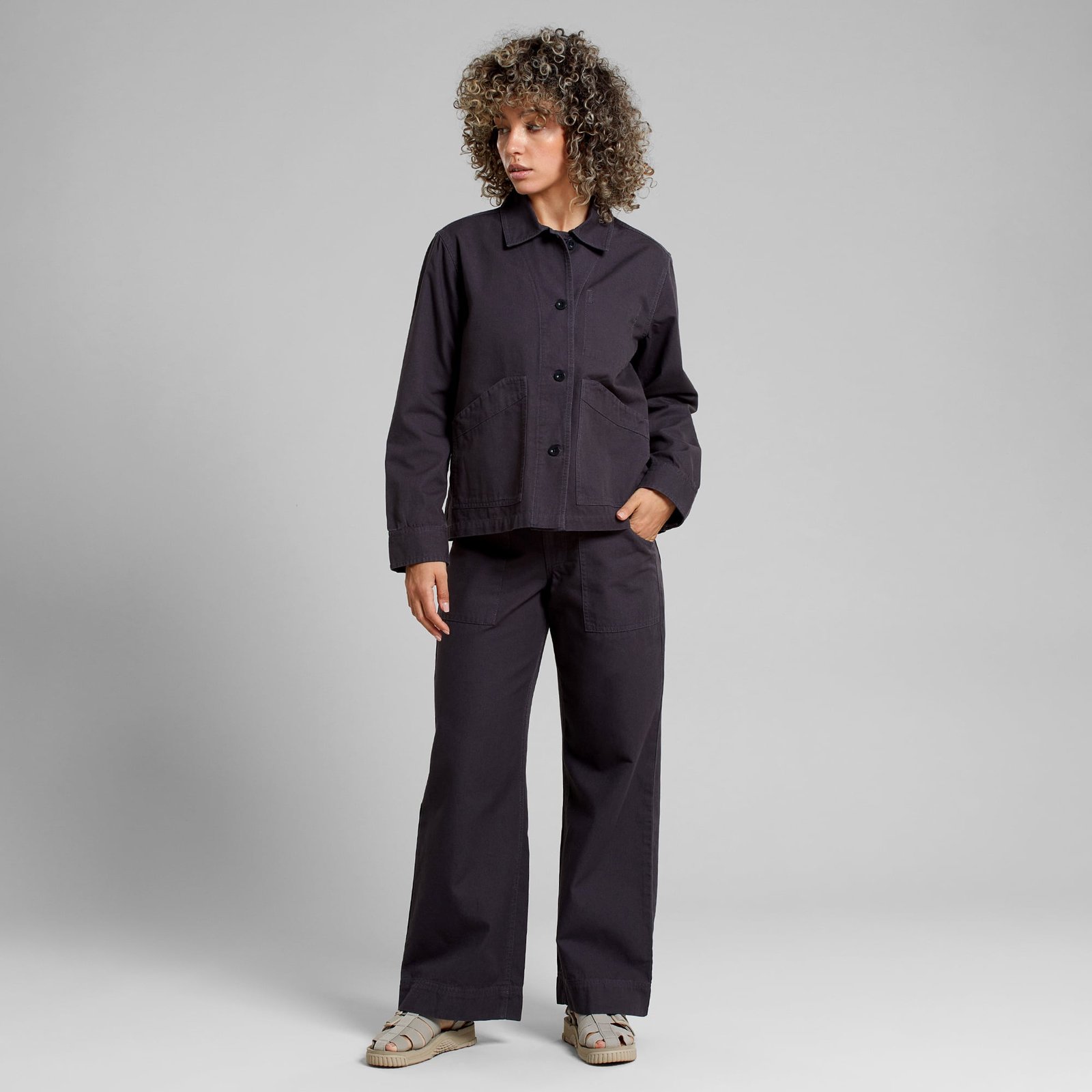 A model wears the relaxed fit Jacket Stiby Canvas in Phantom Black, perfectly paired with matching wide-leg trousers.